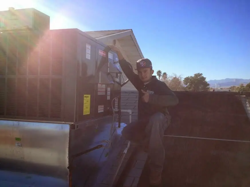 HVAC technician performing AC Tune-Up on a rooftop unit in West Hazleton